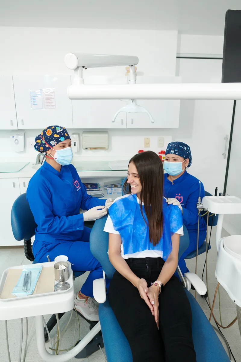 Paciente sonriendo en la clínica con doctoras de Casa de Sonrisas